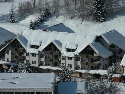 an apartment building is covered in snow at Aparthotel Kupferkanne in Todtmoos