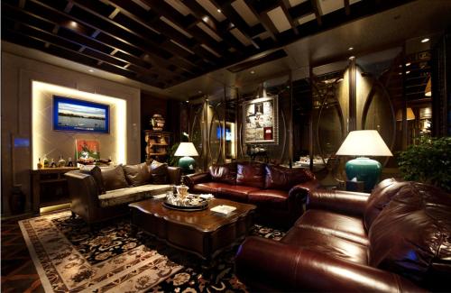 a living room with leather couches and a table at RenHe Spring Hotel in Chengdu