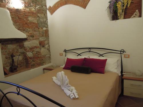 a bedroom with a bed with red and white pillows at Corte Navari - Loft Principe Filippo in Pietrasanta