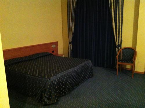 a bedroom with a bed and a chair and a window at Ca' Del Bosco in Budòio