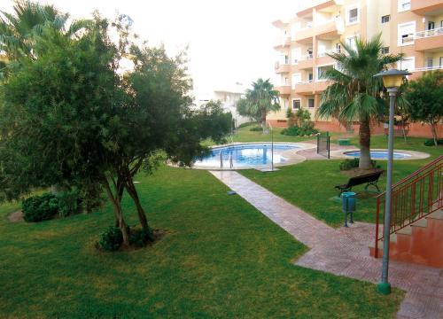 un parque frente a un edificio con piscina en Apartamentos Cibeles, en Roquetas de Mar