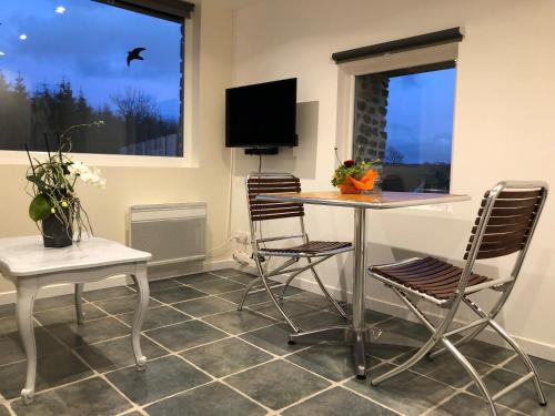 une salle à manger avec une table et des chaises et une télévision dans l'établissement Gite en Normandie, à Montabot