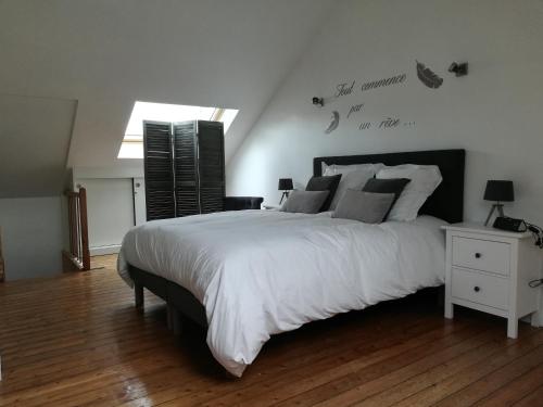 費康的住宿－L Alchimie，卧室设有一张白色大床和一扇窗户。