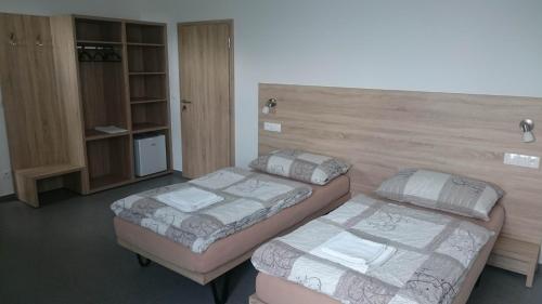 a room with two beds and a cabinet at Penzion Skalka in Skalka