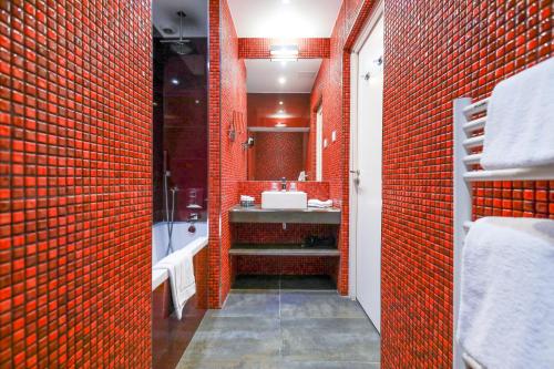 a bathroom with a sink and a red brick wall at Nice Excelsior Centre ville by HappyCulture in Nice