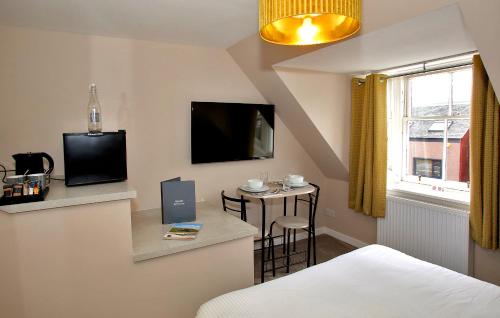 ein Hotelzimmer mit einem Bett und einem kleinen Tisch in der Unterkunft Paton Cottage in Inverness