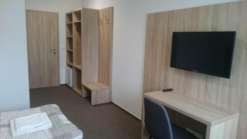 a room with a tv on a wall at Penzion Skalka in Skalka