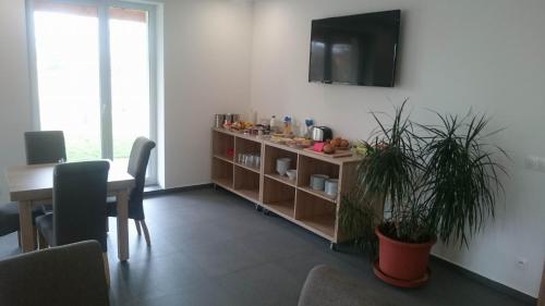 a living room with a table and a television on a wall at Penzion Skalka in Skalka