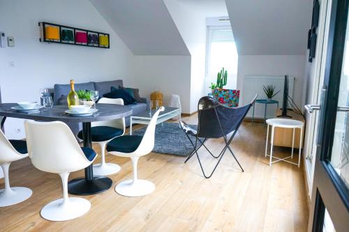 un salon avec une table et des chaises dans l'établissement L'Eden Urbain - 2 Chambres, à Brive-la-Gaillarde