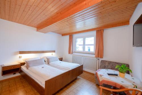a bedroom with a bed and a desk and a window at Gasthof zum Ochsen in Vöhrenbach