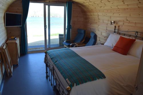 a bedroom with a bed and a large window at The Beach Bothies in Valtos