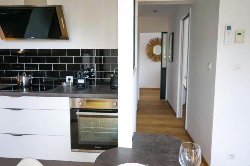 une cuisine avec un évier et une cuisinière four supérieur dans l'établissement L'Eden Urbain - 2 Chambres, à Brive-la-Gaillarde