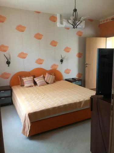 a bedroom with a bed with orange clouds on the wall at Nyaralo Balatonszárszó in Balatonszárszó