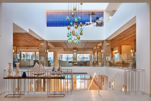 a living room with a dining table and a chandelier at Herbert Samuel Milos Dead Sea in Ein Bokek