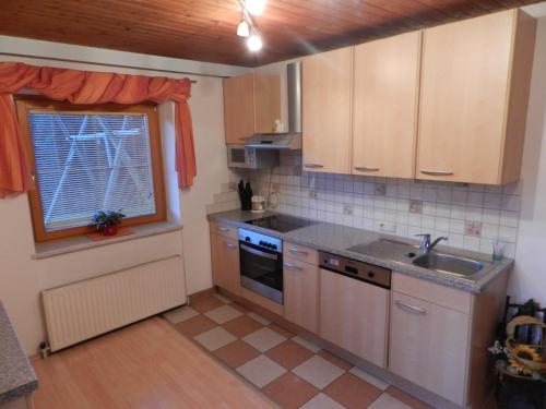 a kitchen with wooden cabinets and a sink and a window at Kleinwidmoos-Apartment in Wagrain