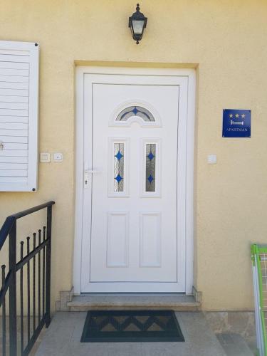 a white door with a window on a building at Apartman Vida in Pula