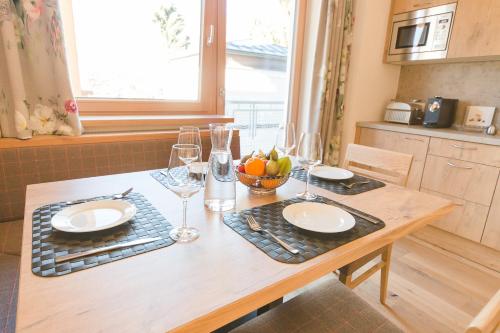 a wooden table with glasses and a bowl of fruit on it at Hotel Giessenbach in Fügen