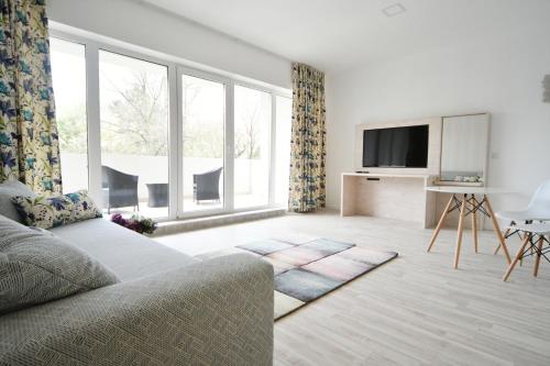 ein Wohnzimmer mit einem Sofa und einem TV in der Unterkunft Moment Apartments in Szolnok