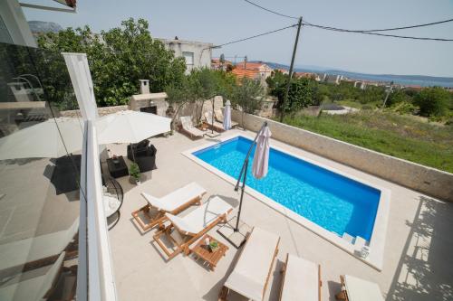a view of a swimming pool with chairs and an umbrella at Villa Sunset in Kastel Novi