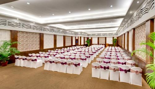 a room with a bunch of tables and chairs at Hotel Hindusthan International, Kolkata in Kolkata