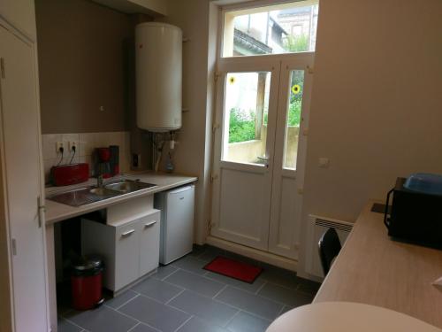 une petite cuisine avec un évier et une fenêtre dans l'établissement Gites de mer Les Boucanes, à Fécamp