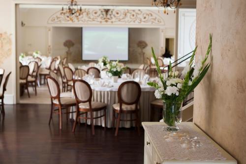 a dining room with tables and chairs and a vase of flowers at Villa Estera - Hotel & Restauracja in Michałowice