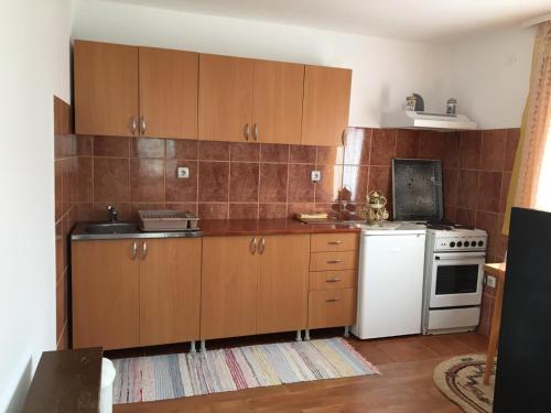 哥魯拜克的住宿－Apartmani Vidikovac，厨房配有木制橱柜和白色冰箱。
