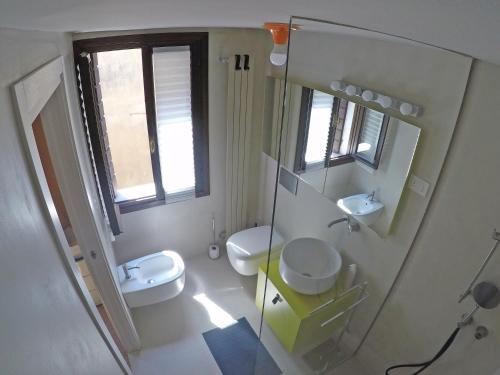 a bathroom with two toilets and a sink and a mirror at San Polo Family Apartment in Venice