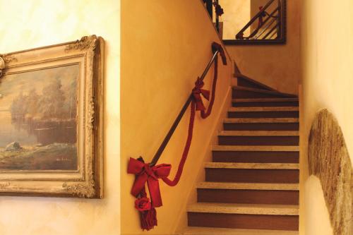 a staircase with red bows on the wall and a painting at La Giada in Tivoli