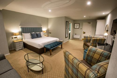 a hotel room with a bed and a couch at Abbey Hotel Golf & Spa in Redditch