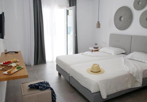 a bedroom with a bed with a hat on it at Casabella in Naxos Chora