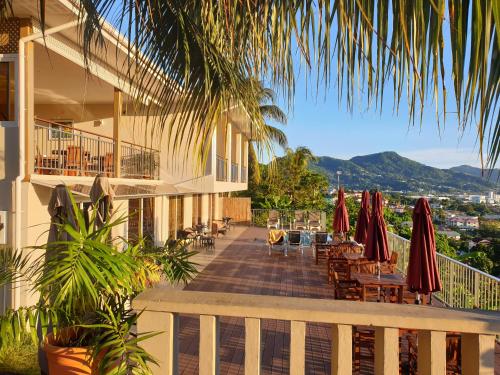 a balcony of a hotel with tables and umbrellas at The Ridge Residence in Victoria