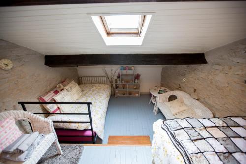 a attic room with two beds and a window at La Maison Des Fleurs in Montembœuf