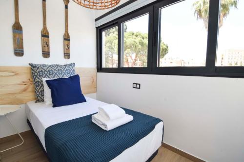 a bedroom with a bed with blue and white sheets at Letmalaga Carlos Haya in Málaga