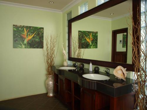 a bathroom with two sinks and a large mirror at The Gecho Inn Town in Jepara