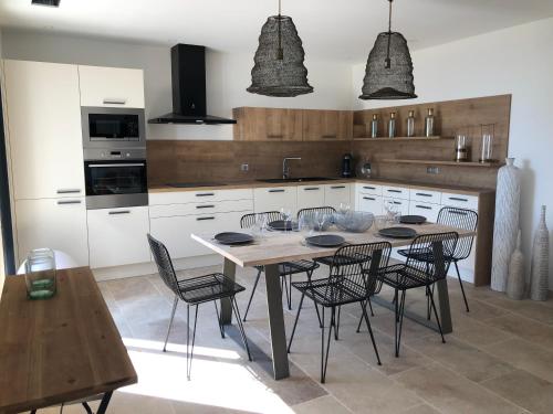 a kitchen with a table and chairs in it at LA POINTE D’ASPRETTO in Ajaccio