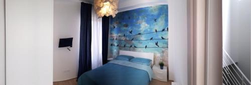 Un dormitorio con una cama azul con una pintura en la pared en Reggia del sole, en San Benedetto del Tronto