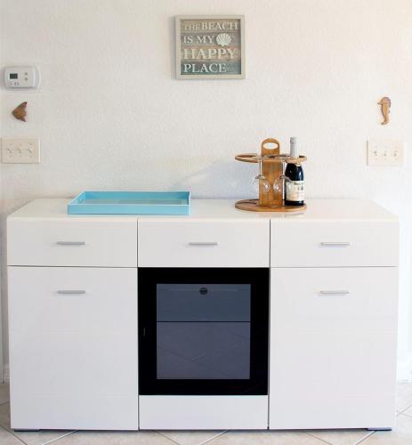 a kitchen with a white counter with a black oven at Chic Ocean Getaway - Walk to Beach, Pool & Hot Tub in Fort Pierce