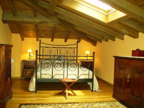 1 dormitorio con cama de hierro forjado en Casa Rural Carrio, en Taranes