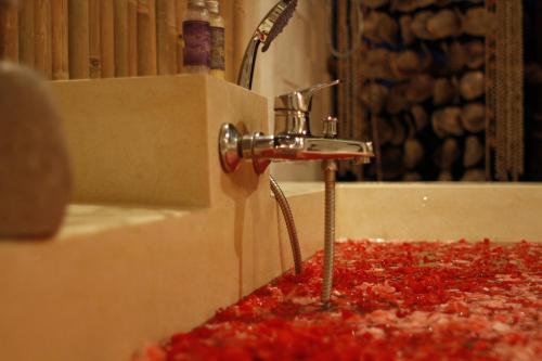 a bathroom sink with red liquid under a faucet at La Cabane in Jimbaran
