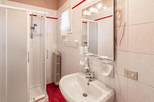 y baño blanco con lavabo y ducha. en Hotel La Favorita en Peschiera del Garda