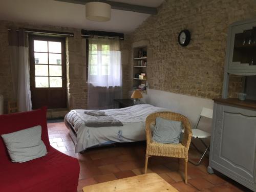 ein Schlafzimmer mit einem Bett, einem Stuhl und einem Sofa in der Unterkunft GITE DES CHOUETTES in Muron