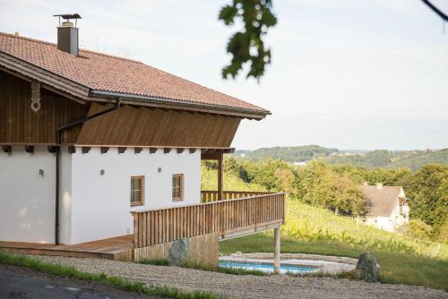 a house with a wooden deck next to a building at Liebe zur Steiermark / Haus Tyrol in Jagerberg