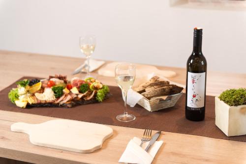 a table with a plate of food and a bottle of wine at Liebe zur Steiermark / Haus Tyrol in Jagerberg