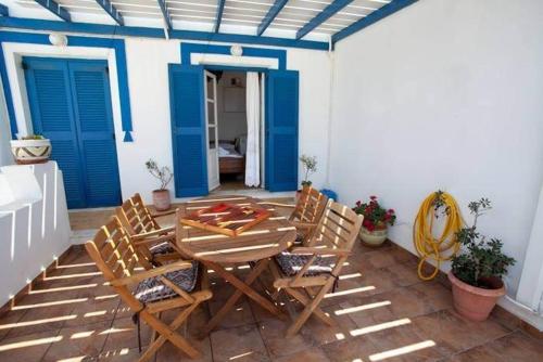 a patio with a table and chairs and blue doors at Katerina Rooms in Naousa