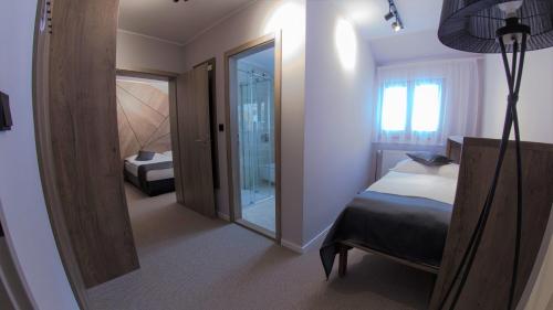 a bedroom with a bed and a glass door at Hotel Praha in Špindlerův Mlýn