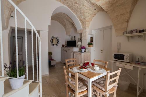 a kitchen and dining room with a table and chairs at Casa Antica Pietra Bianca in Ostuni