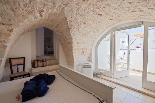 a bedroom with a large bed with an archway at Casa Antica Pietra Bianca in Ostuni