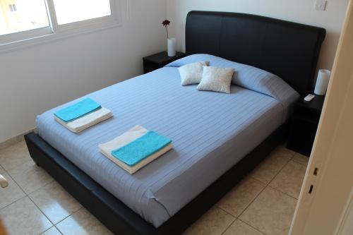 a bedroom with a bed with blue sheets and pillows at Estia Luxury Maisonette in Paphos