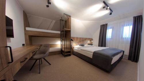 a bedroom with a bed and a desk and a bed sidx sidx sidx at Hotel Praha in Špindlerův Mlýn